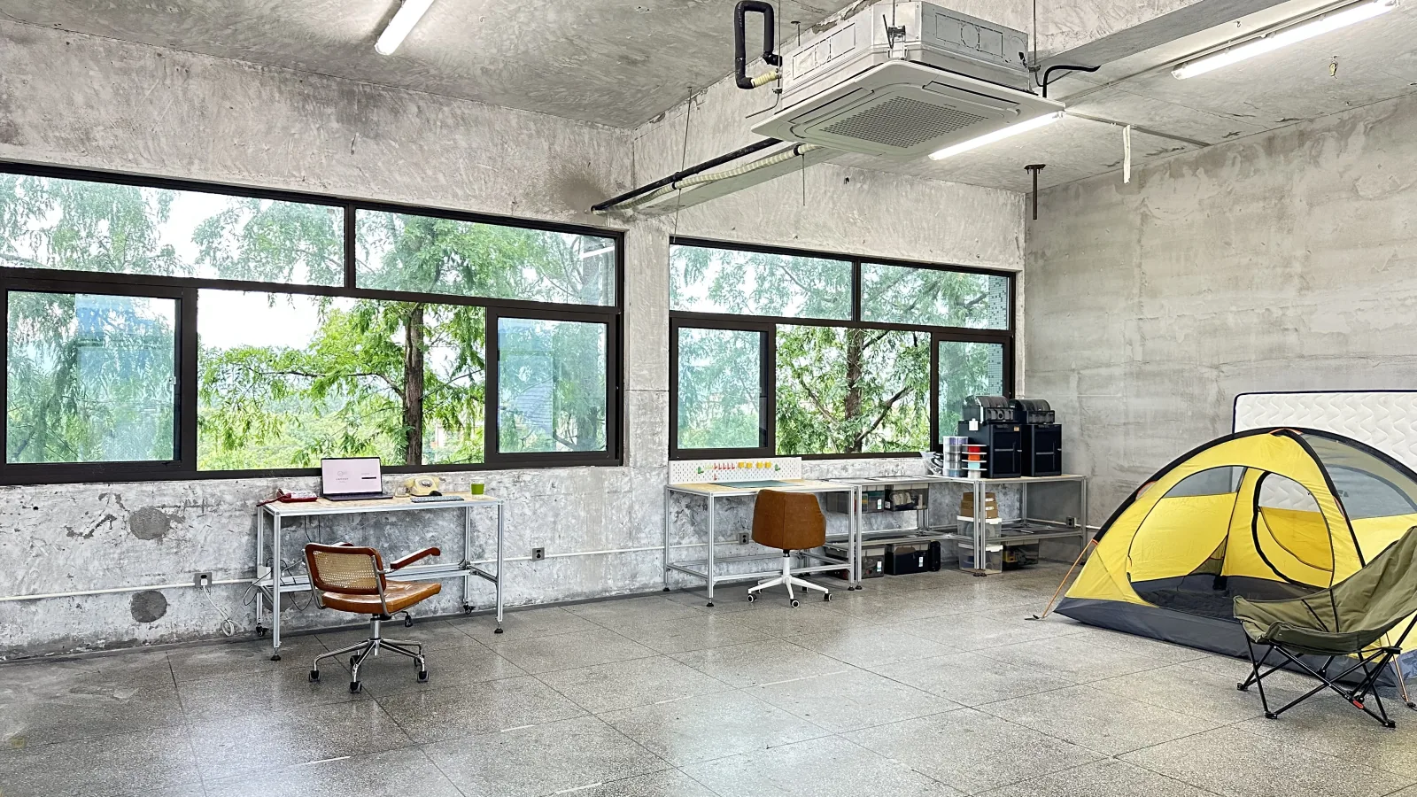 The Hao Lab studio: a concrete room with workbenches, prototypes, and a yellow tent