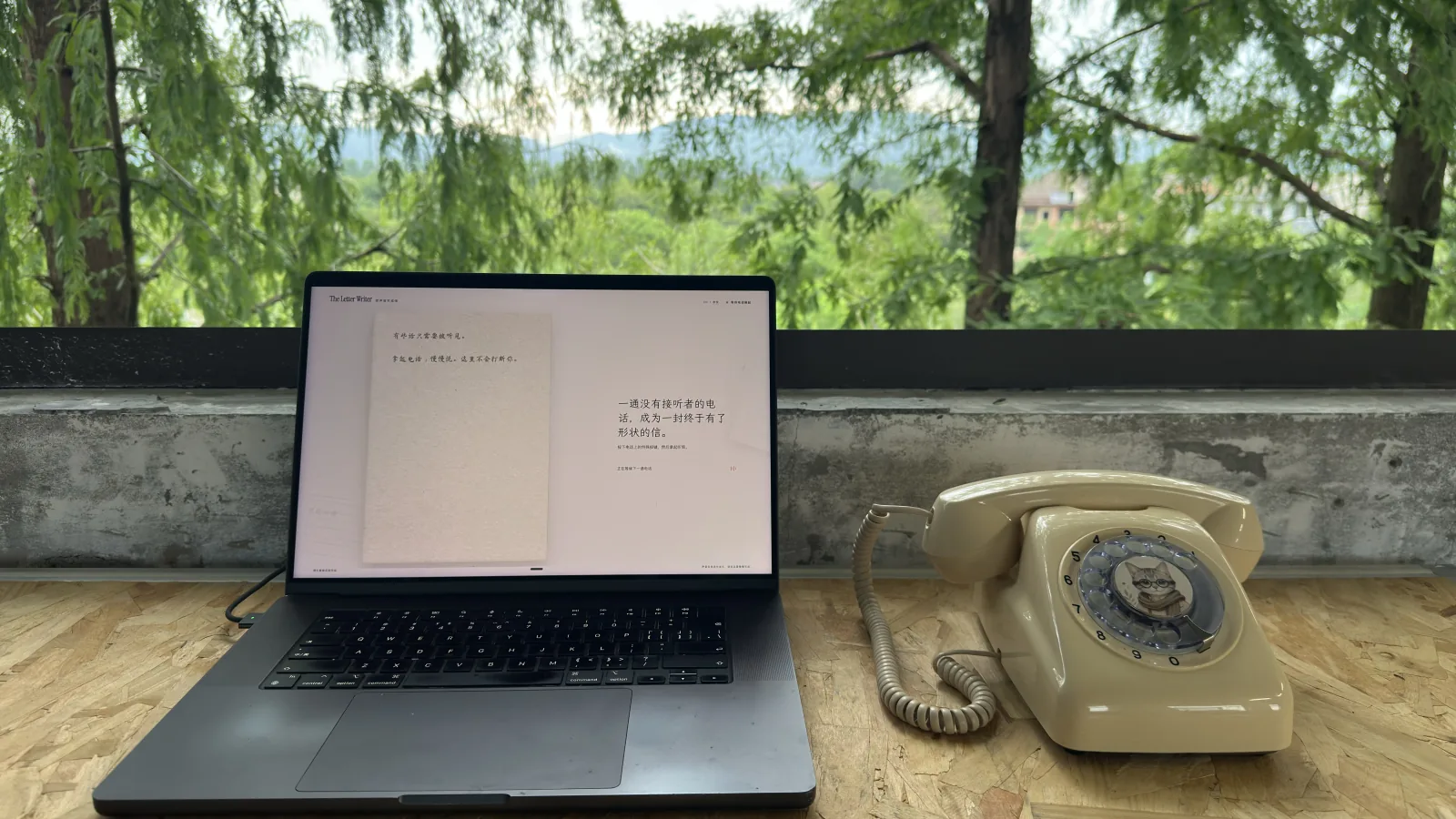 A cream rotary telephone beside a laptop showing The Letter Writer prototype in Hao Lab